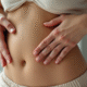 Femme appliquant doucement de l'huile sur son abdomen