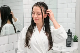 Femme aux cheveux brillants après lavage avec le shampoing Kevin Murphy dans une salle de bain moderne et épurée