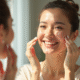 Femme d'âge moyen appliquant un maquillage naturel devant un miroir en lumière douce