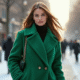 Femme élégante en manteau vert dans la ville enneigée