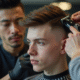 Jeune homme en salon de coiffure avec coupe fade précise